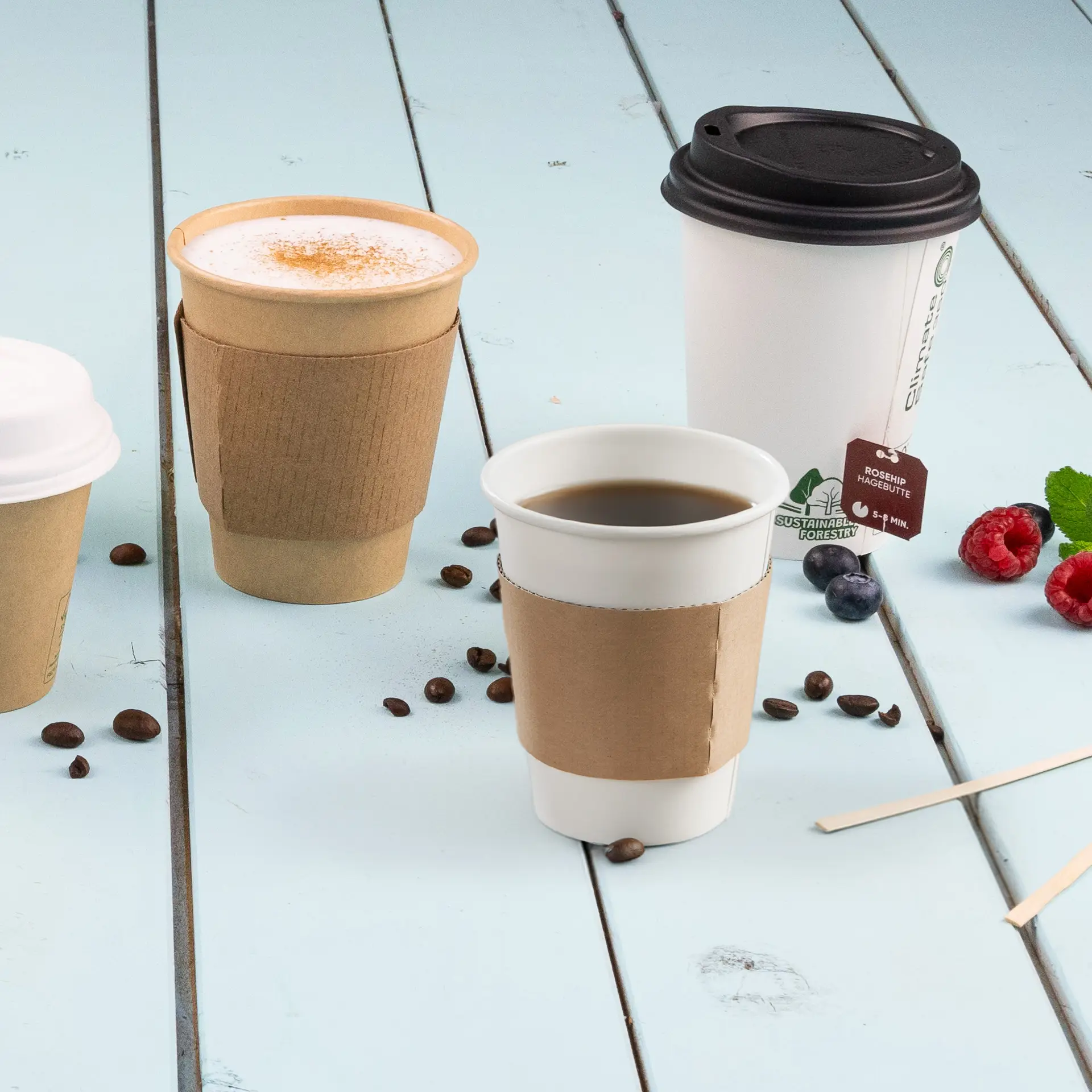Brauner Pappbecher-Sleeve für 150/200/250 ml Papierbecher, auf einer blauen Holzoberfläche mit Kaffeebechern platziert.