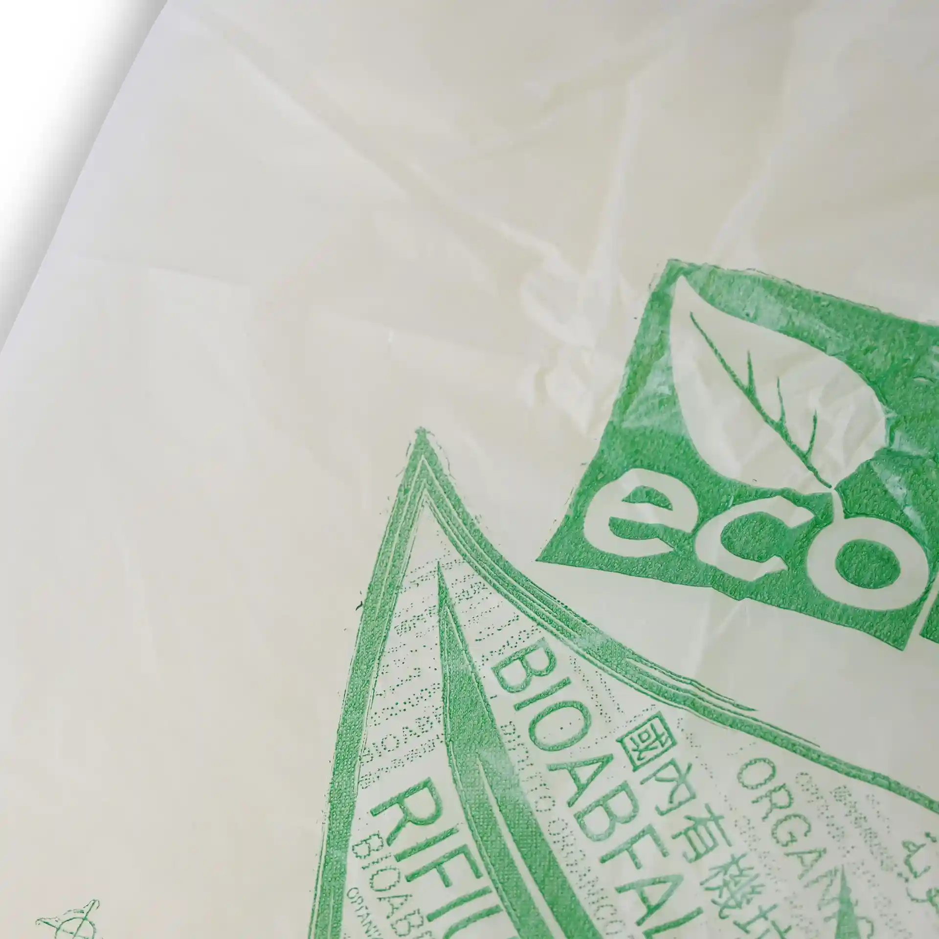 Transparent bio bin bag with green printed eco-friendly symbols and markings, measuring 70x70 cm.