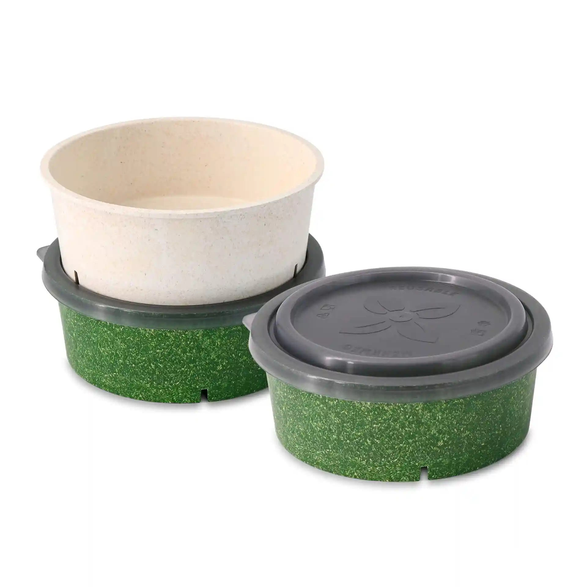 Zwei runde Schalen, eine beige und eine grüne, mit einem grauen wiederverwendbaren Deckel auf der grünen Schale.