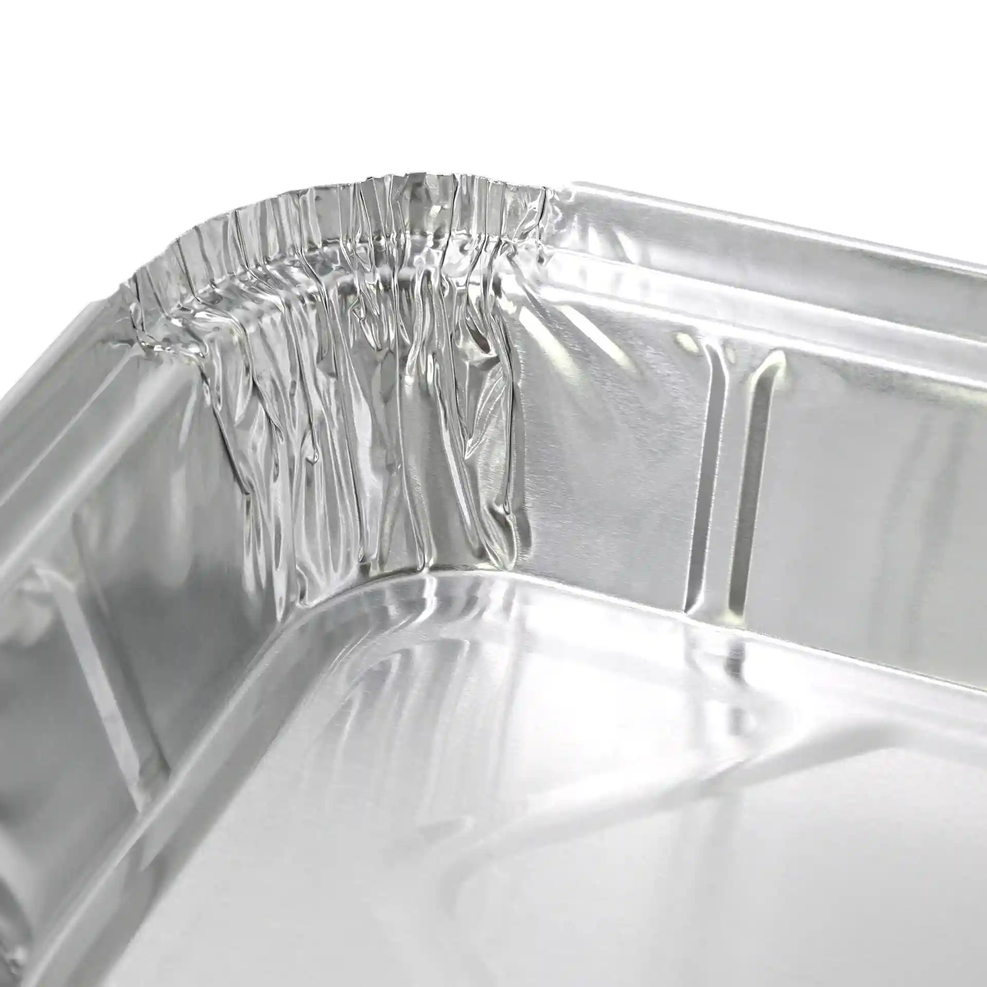 Nahaufnahme der Ecke eines rechteckigen Aluminiumbehälters, zeigt die gekrümmte Kante und die glänzende Oberfläche.