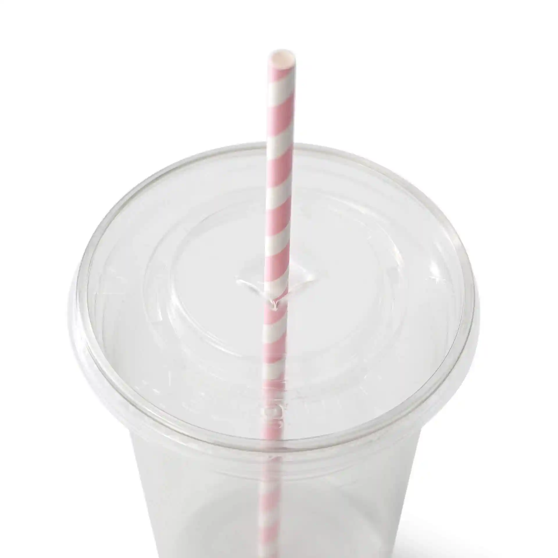 Klarer Becher mit einem pastellfarbenen gestreiften Papierstrohhalm, von oben betrachtet.