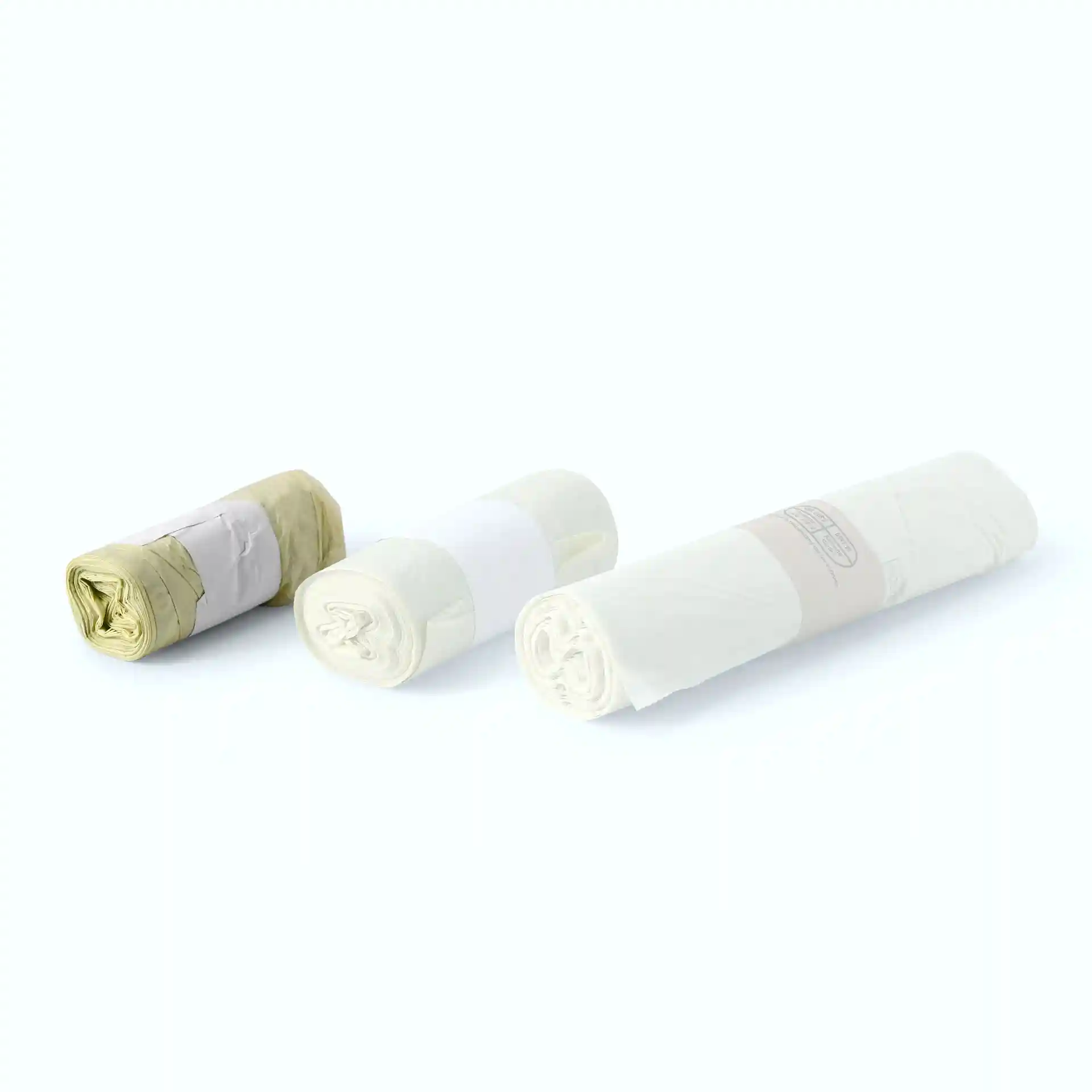 Three rolls of transparent bio bin bags made from PLA, each rolled and secured with bands.