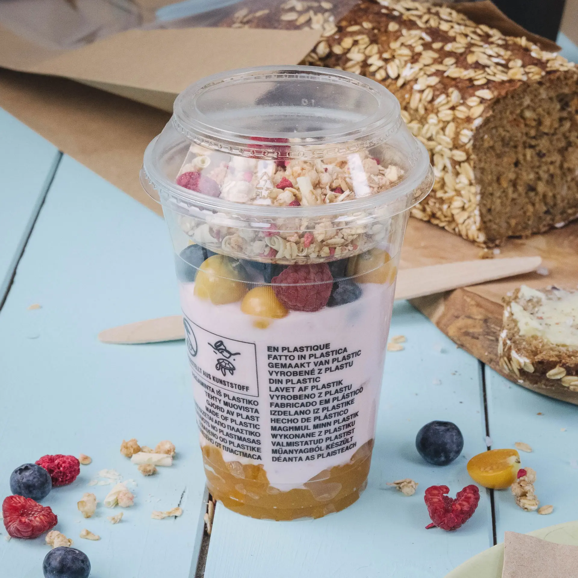 Klarer Plastikbecher gefüllt mit Joghurt, Müsli und Obst, Durchmesser 95 mm, Volumen 130 ml.