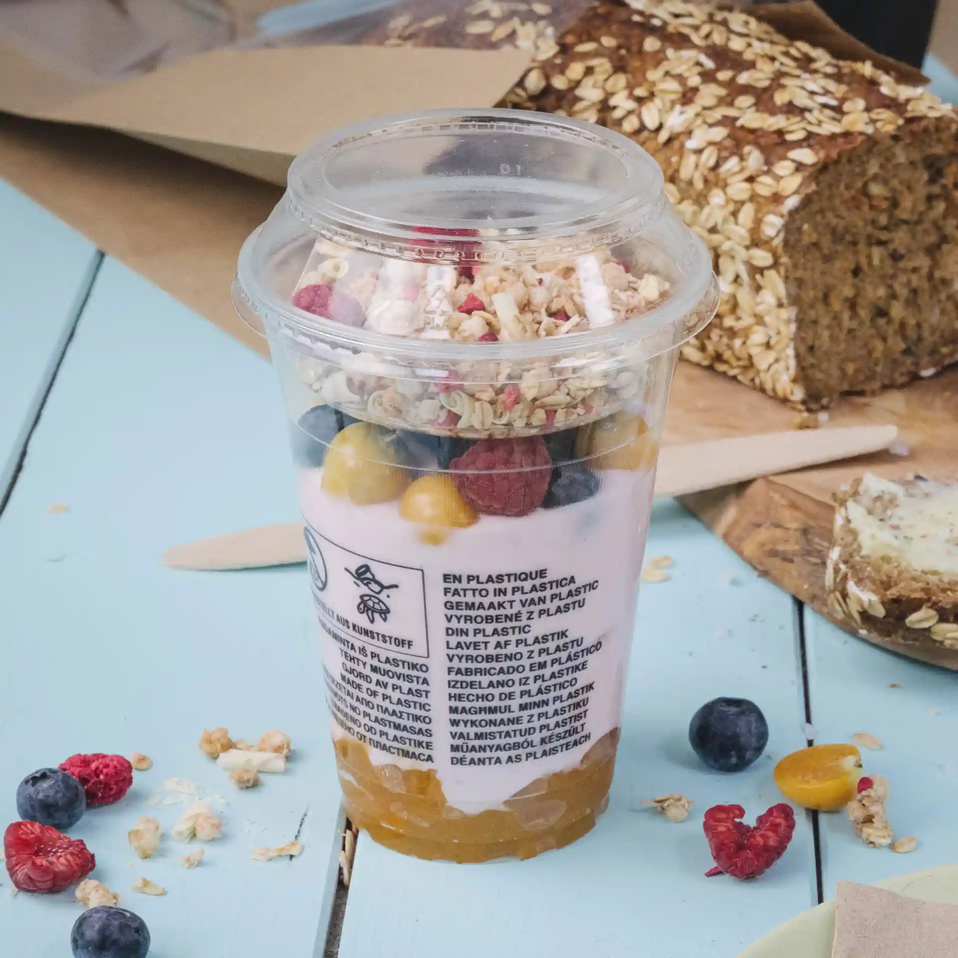 Klarer Plastikbecher gefüllt mit Joghurt, Granola und gemischten Früchten, Durchmesser 95 mm.