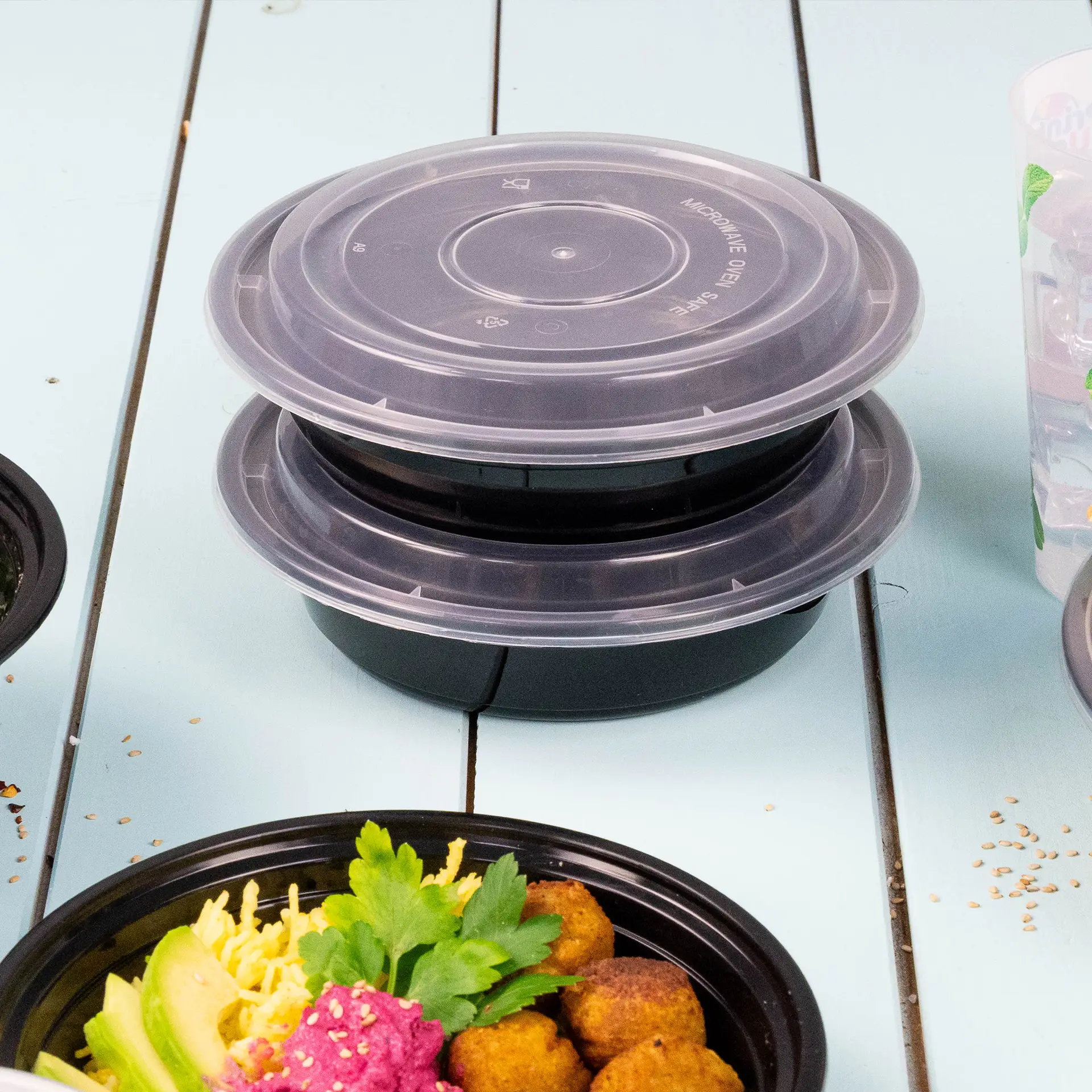 Reusable transparent lid for food containers, designed for hot and cold dishes, shown stacked on black bases.