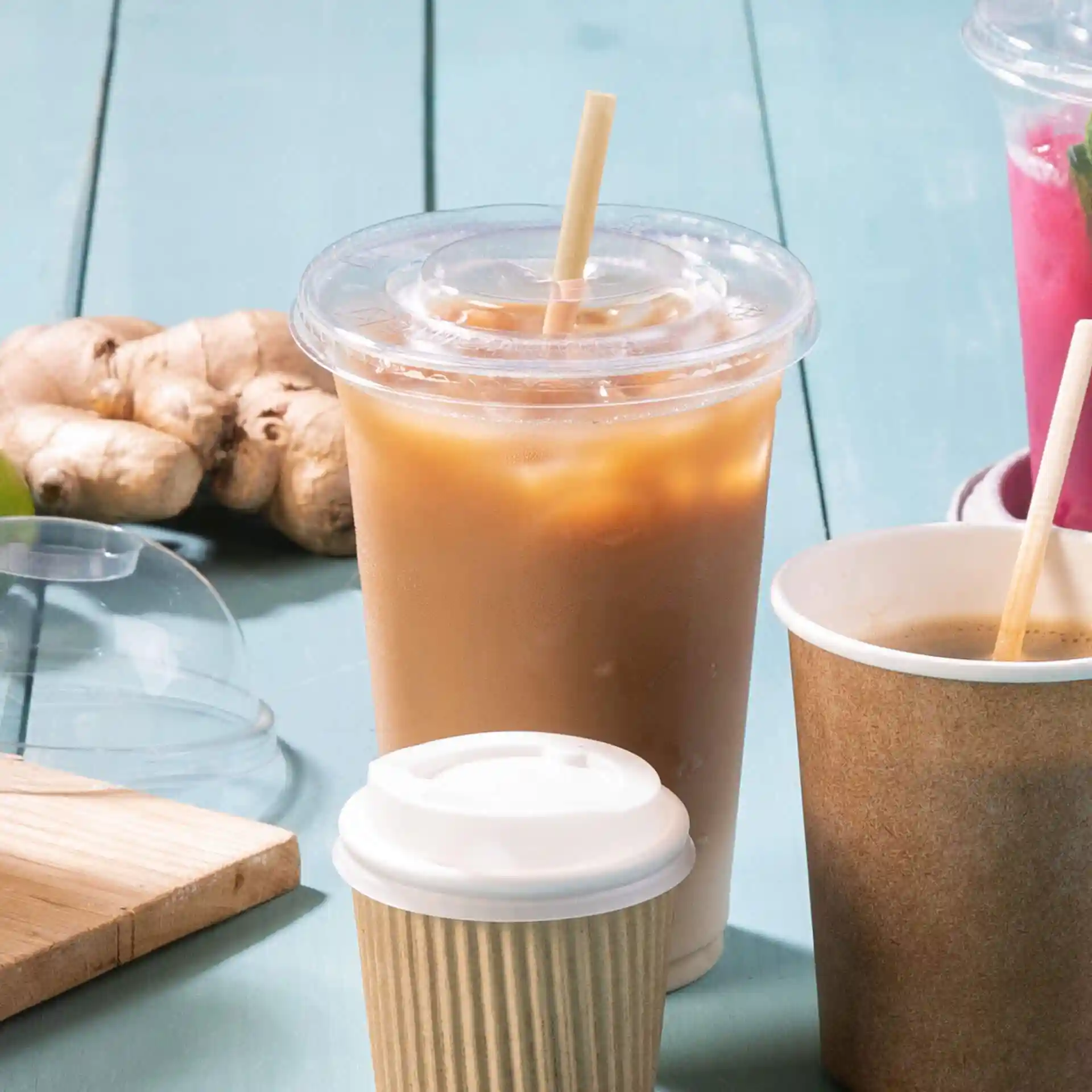 Image of a brown paper drinking straw, 20 cm long, placed beside various beverages on a blue surface.